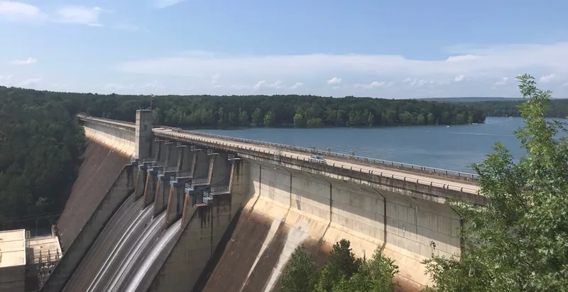 Greers Ferry Dam with water running down the spillway and Greers Ferry Lake behind it