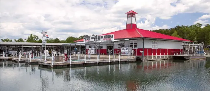 Peters Sugar Loaf Marina building with a red roof and a lighthouse-style tower, beside covered boat docks