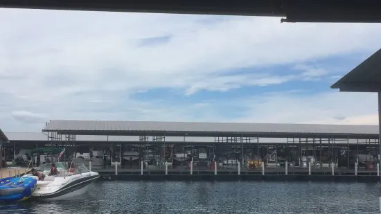 Covered boat slips on the water, with a boat and a tube tied up in the foreground